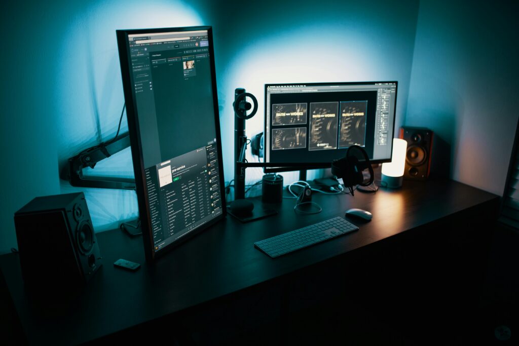 pexels-photo-1714208-1714208 A contemporary office desk featuring a dual monitor setup with stylish lighting, ideal for tech enthusiasts.