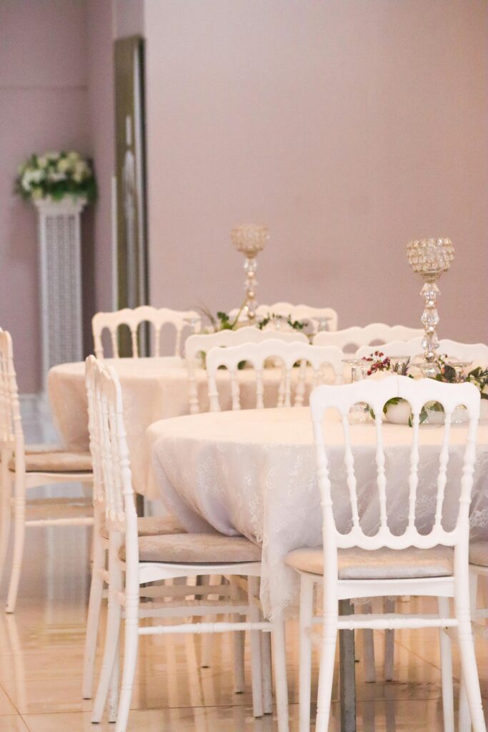 pexels-photo-31253384-31253384 Chic banquet hall with white chairs, round tables, and candelabras, perfect for elegant events.